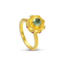 Load image into Gallery viewer, Reminiscent of a bejeweled Orb, instead of a customary cross mounted top it, this one has a mysterious seafoam blue green tourmaline cut in a bullet style cabochon. A band of delicious purple grape garnets and golden balls of granulation surrounding it. Wear as a single ring or write your own hand story by mixing with your favorite stacking bands or other Orb rings. Made in recycled 22k yellow gold, a Mozambiquan tourmaline (.95ctw) and garnets from Orissa, India (.15ctw). Size 7. Made to order.