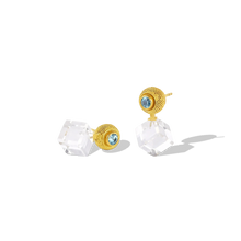 Load image into Gallery viewer, This variation on the classic stud earring has the silky appearance of a velvet cushion. The gold granules are  smooth and almost soft to the touch, giving an almost hypnotic feel to the fingertips. The rich, buttery mellow tone of the yellow gold soften the bold, angular and contemporary lines of the custom cut rock crystal cubes and the glittering blue zircons provide a vivid pop of color. 

Made from recycled 22k gold, Cambodian zircon (.83ctw) and rock crystal (18.91ctw).
