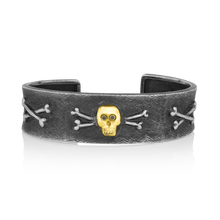 Load image into Gallery viewer, One of our most popular cuff bracelets began life as a sketch of the skull and crossbones on a client's favorite pair of socks. Those who order The Skull Bracelet find that it becomes exceptionally well-traveled as it rarely leaves their wrists. One such journey had a small child, seated next to a proud owner, lean over to her father and ask "Daddy, is that man a pirate?" Enough said.

Handmade to order. Please allow 6-8 weeks for its creation.
