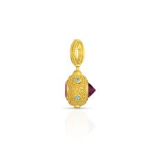 Load image into Gallery viewer, Deep purplish red rhodolite garnets set in reverse at the front like a spike, regular set at the back give a medieval look to this distinctive charm. A distinct and different choice for everyday wear. Bright blue zircon studs set around the hexagons provide a discreet sparkle and pop of color. Length approximately 35 mm or 1.38 in. Made from recycled 22k yellow gold, rhodolite garnets (2.15ctw) and blue zircons (.11ctw).